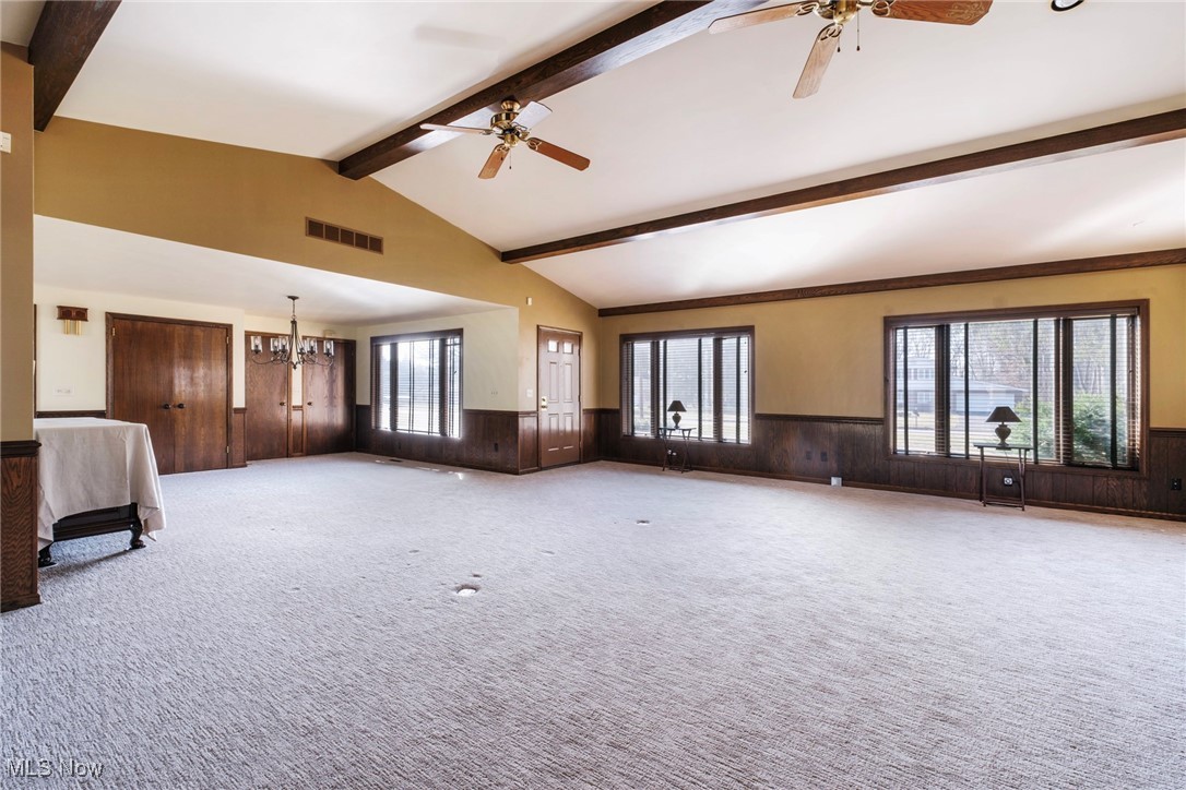 7059 Stewart Sharon Road Hubbard, OH 44425 - Photo 11 of 49 Unfurnished living room with a wainscoted wall, ceiling fan with notable chandelier, and visible vents