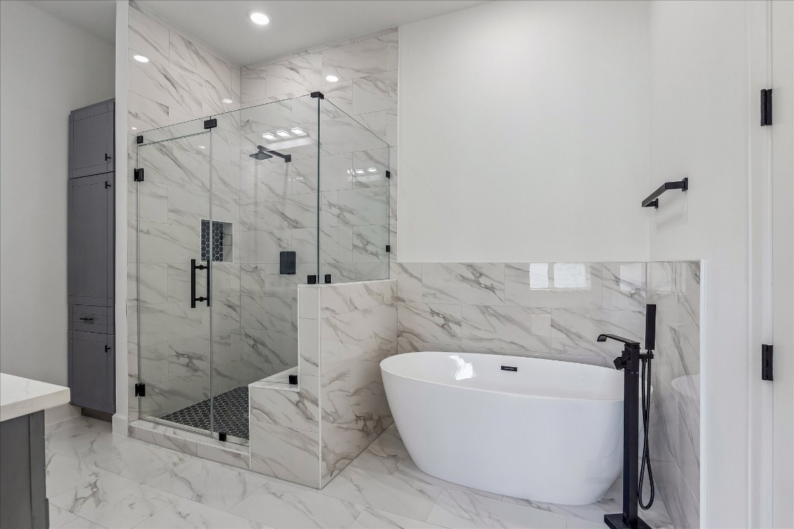 9426 Campbell Road, Unit A Houston, TX 77080 - Photo 10 of 17 A luxurious soaking tub, and an expansive, fully tiled layout adorned with premium finishes. Modern fixtures and meticulous design elevate the space, creating a spa-like retreat that seamlessly blends style, comfort, and functionality.