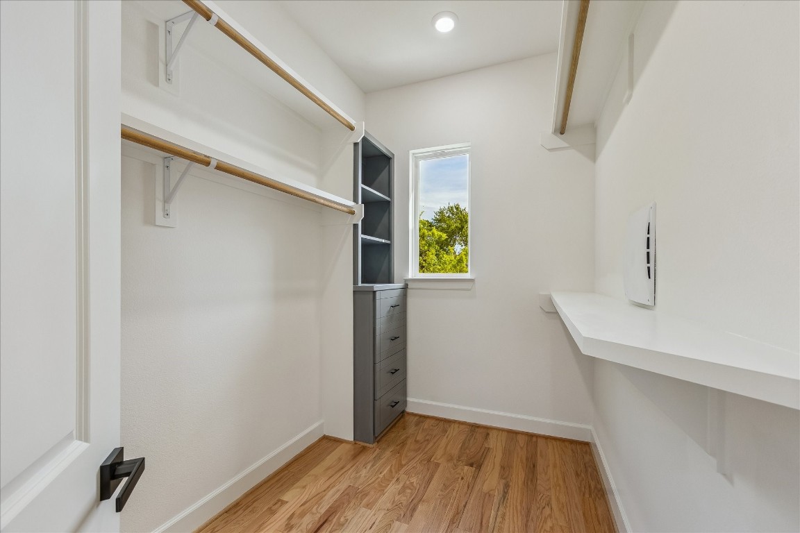9426 Campbell Road, Unit A Houston, TX 77080 - Photo 12 of 17 Luxurious primary bedroom closet featuring a window that bathes the space in natural light, complemented by built-in shelves and drawers for organized, elegant storage. This thoughtfully designed retreat combines functionality with refined style.