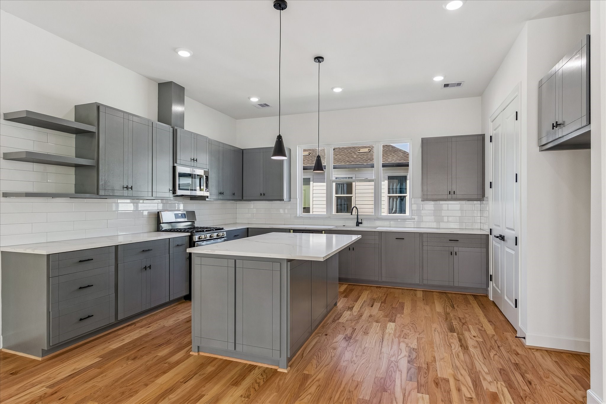 9426 Campbell Road, Unit A Houston, TX 77080 - Photo 2 of 17 a large kitchen with stainless steel appliances a large counter top a stove a sink and a refrigerator