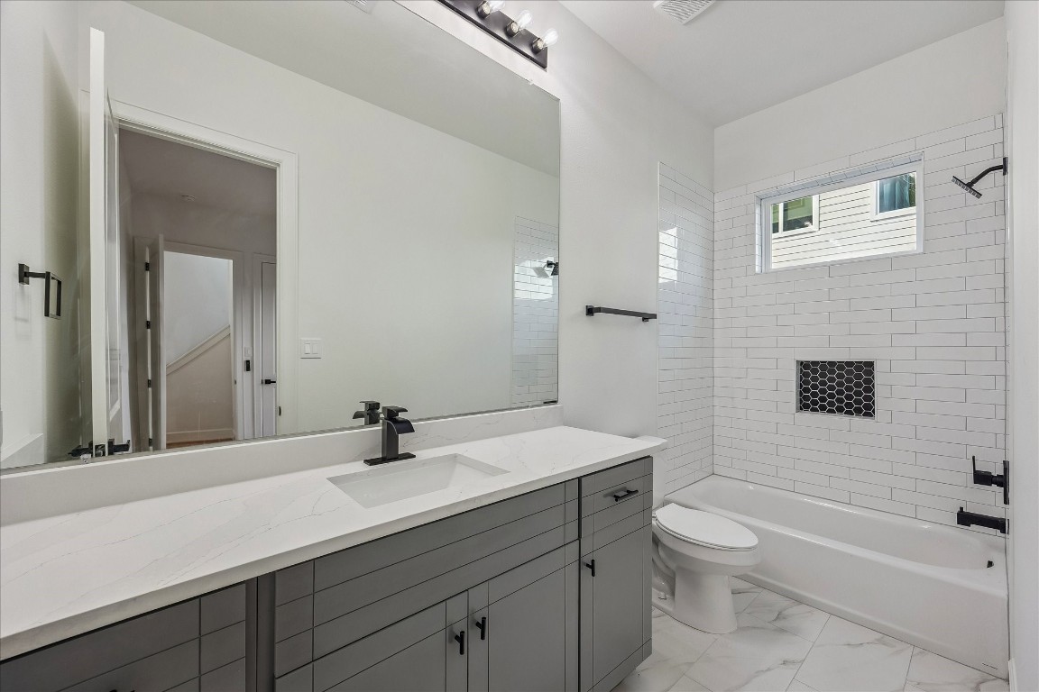 9426 Campbell Road, Unit A Houston, TX 77080 - Photo 4 of 17 Ensuite bathroom featuring sleek modern fixtures and a stylish tub/shower combination, offering both functionality and contemporary appeal. Thoughtfully designed with clean lines and quality finishes, creating a comfortable and inviting space for daily living.