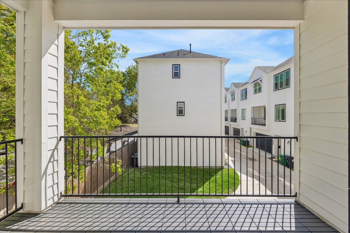 9426 Campbell Road, Unit A Houston, TX 77080 - Photo 8 of 17 Expansive balcony seamlessly extending from the living room, offering serene views of lush trees and the charming community Chateaus. This inviting outdoor space provides the perfect setting for relaxing, entertaining, or simply enjoying the picturesque surroundings.