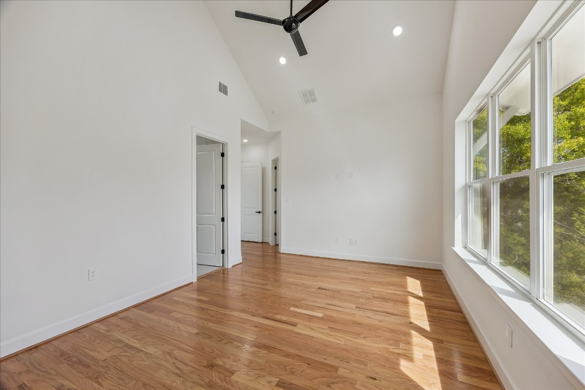 9426 Campbell Road, Unit A Houston, TX 77080 - Photo 9 of 17 Elegant primary bedroom featuring a grand window that fills the space with natural light, highlighting the beautiful, high-quality flooring. This serene retreat combines spaciousness and refined finishes, creating a perfect sanctuary for rest and relaxation.