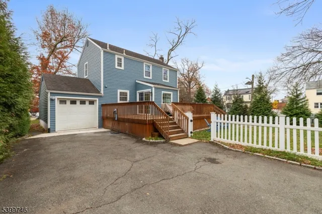 a view of a house with a small yard and wooden fence