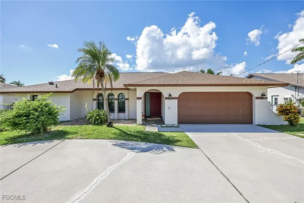 a front view of a house with a yard and a garage