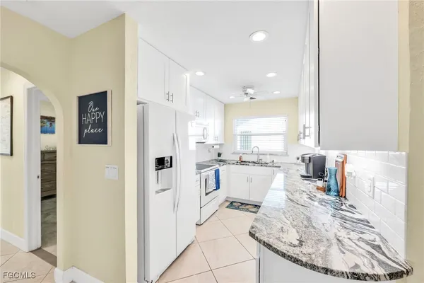 a kitchen with white cabinets and refrigerator