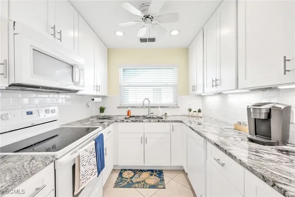 a kitchen with a sink a stove a microwave and cabinets