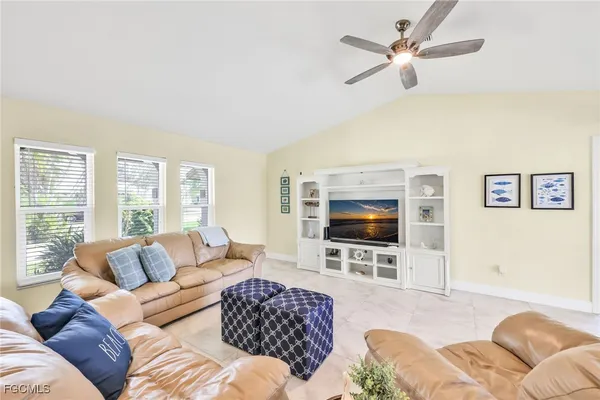 a living room with furniture a ceiling fan and a flat screen tv