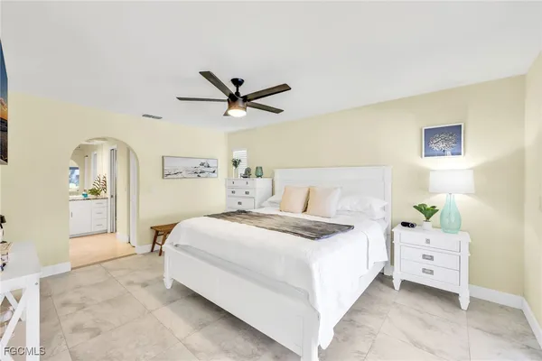 a spacious bedroom with a bed and a chandelier