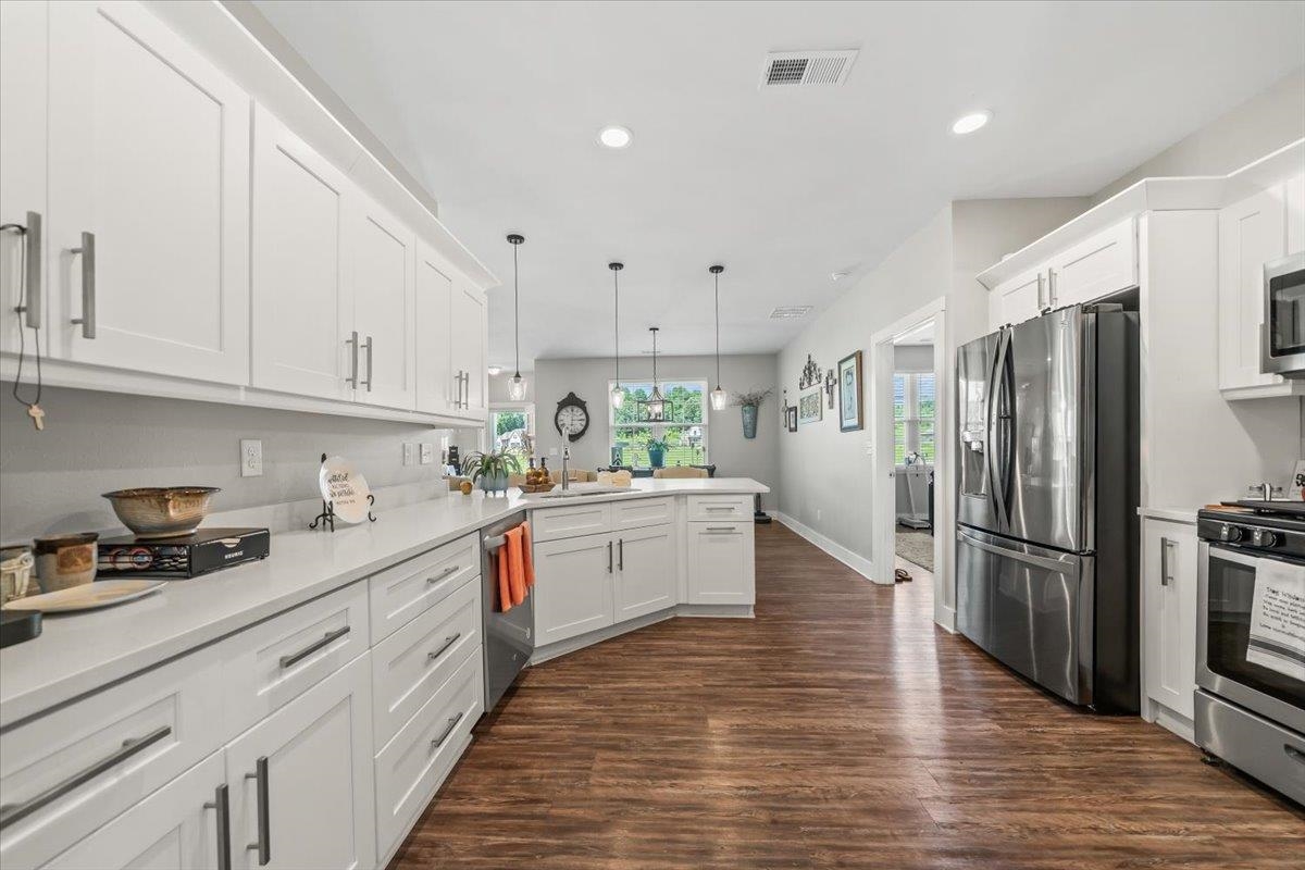 415 Abbey Road, Unit D Munford, TN 38058 - Photo 15 of 35 Modern kitchen featuring white cabinetry, light-toned countertops, stainless steel appliances, wood-finish flooring, and recessed lighting