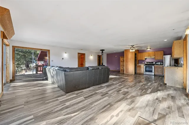 a living room with furniture a flat screen tv and a kitchen area