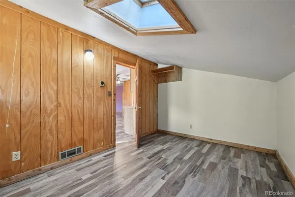 a view of a hallway with wooden floor and closet