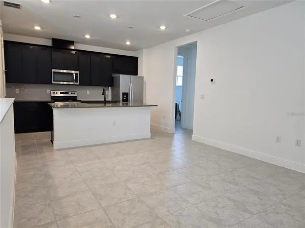a view of kitchen with kitchen island microwave and cabinets