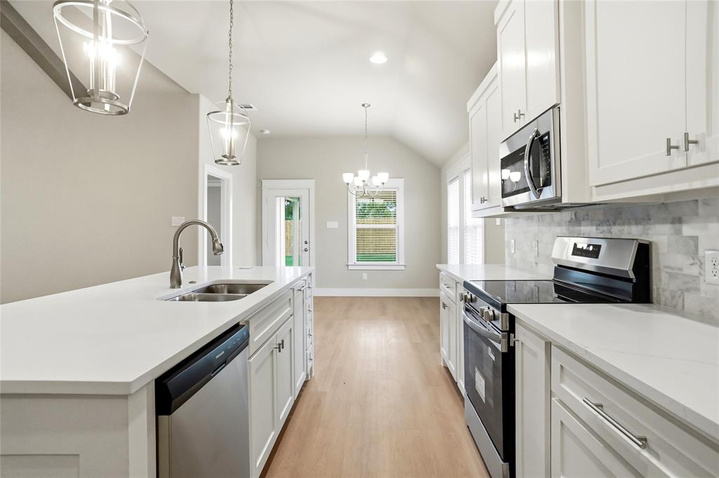 133 Joel Street Springtown, TX 76082 - Photo 5 of 15 a kitchen with stainless steel appliances a sink a stove and a wooden floors