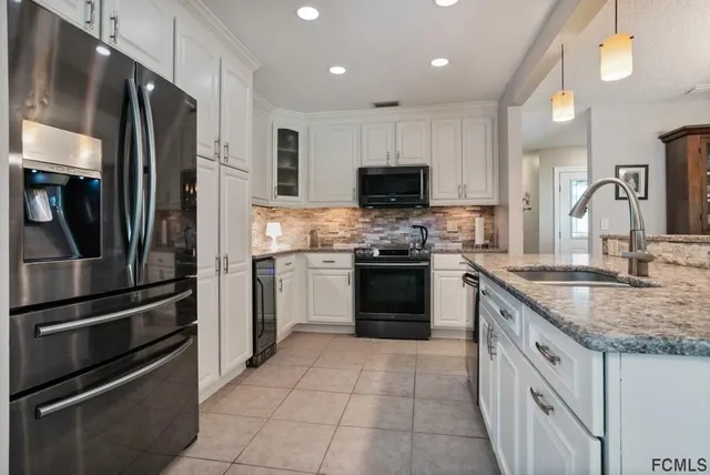a kitchen with stainless steel appliances granite countertop a refrigerator sink and stove