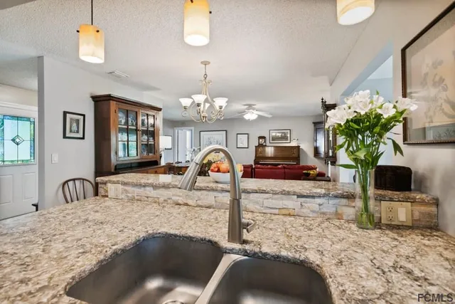 a kitchen with stainless steel appliances kitchen island granite countertop a table and chairs in it