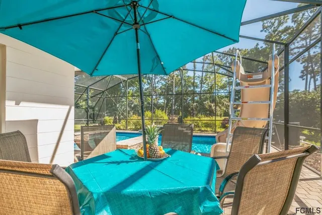 a view of a swimming pool with a lounge chair and trees