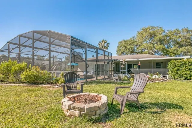 an aerial view of a house with a yard swimming pool and outdoor seating