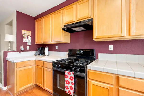 a kitchen with a refrigerator and a stove top oven