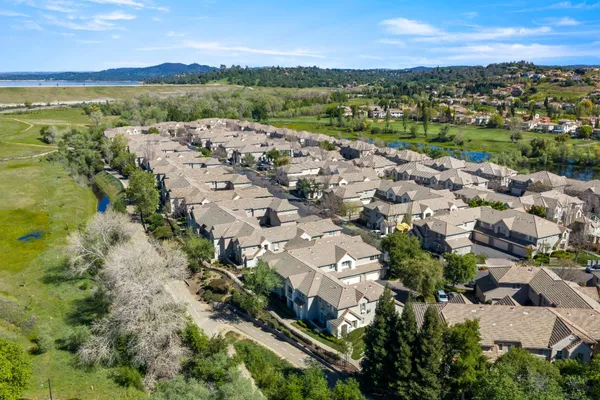an aerial view of a house with a garden and lake view
