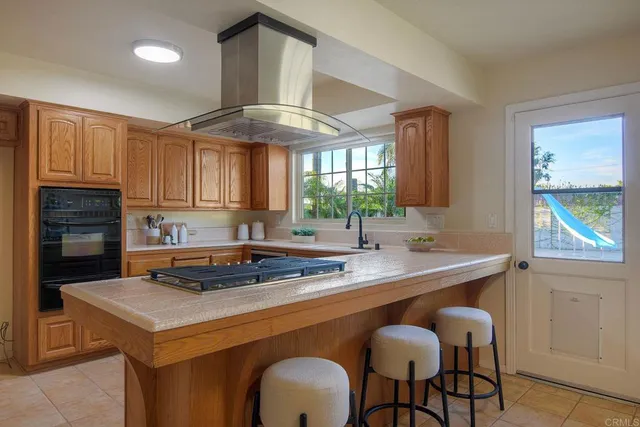 a kitchen with a stove a sink cabinets and a window