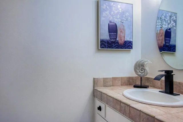 a bathroom with a granite countertop sink and a mirror