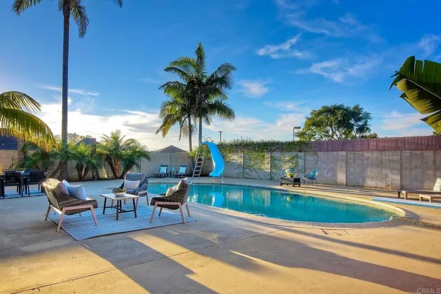 a swimming pool with outdoor seating and yard