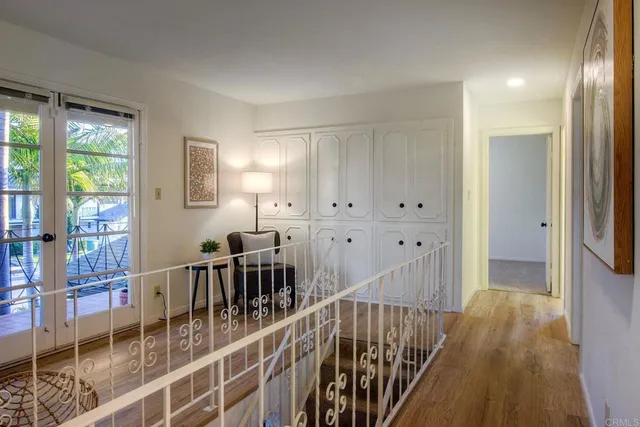 a view of a hallway with wooden floor and windows