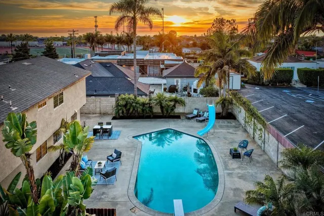 an aerial view of a house with outdoor space and trees all around