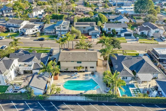 an aerial view of residential houses with outdoor space and parking