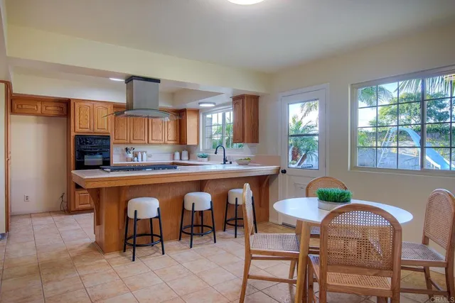 a open kitchen with stainless steel appliances granite countertop a table and chairs in it