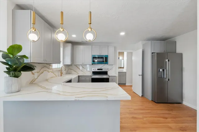 a view of a kitchen with a sink and refrigerator