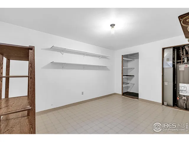 a view of an empty room with closet and a window