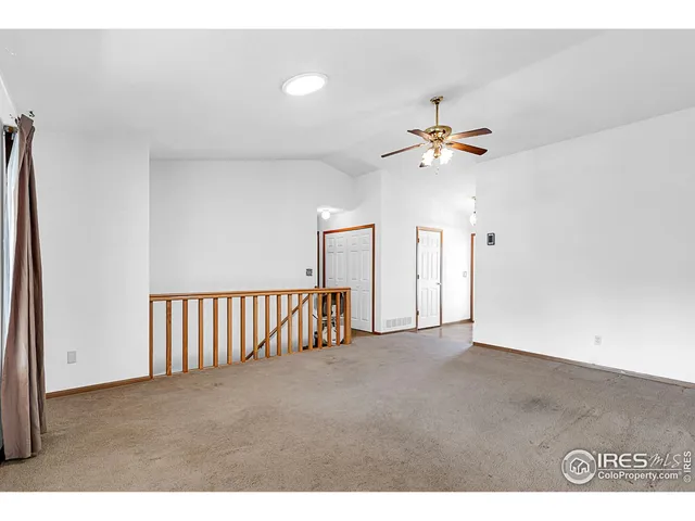 a view of an empty room with a ceiling fan