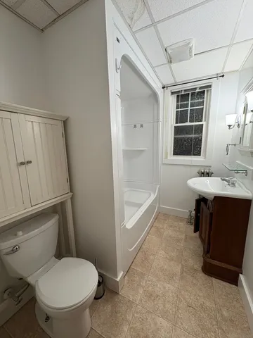 a bathroom with a sink a toilet a mirror and shower