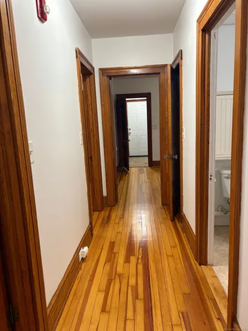 a view of a hallway with wooden floor and staircase