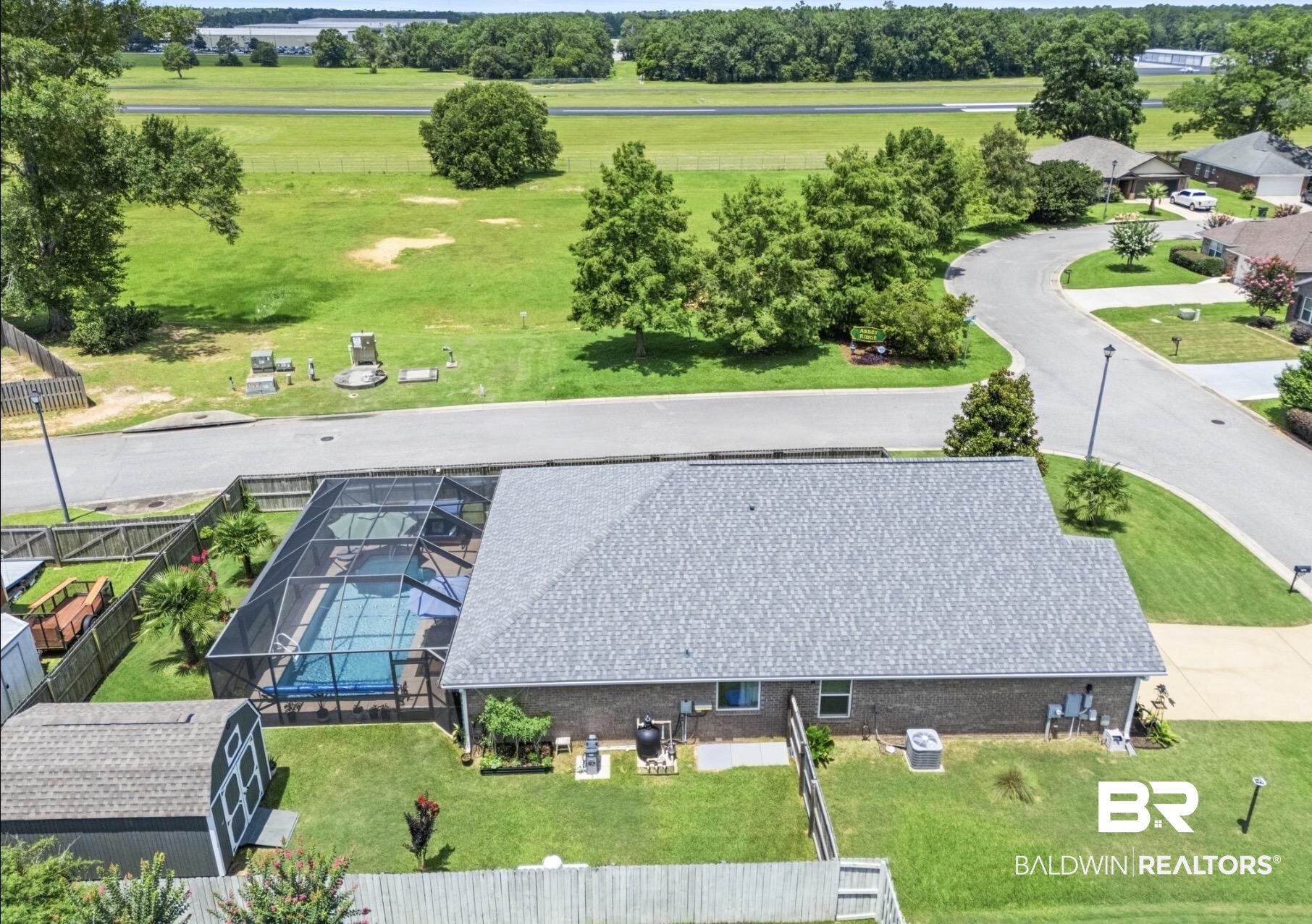 1676 Abbey Loop Foley, AL 36535 - Photo 3 of 31 Aerial perspective showcasing a screened-in swimming pool, a gray shingle roof, and a detached shed