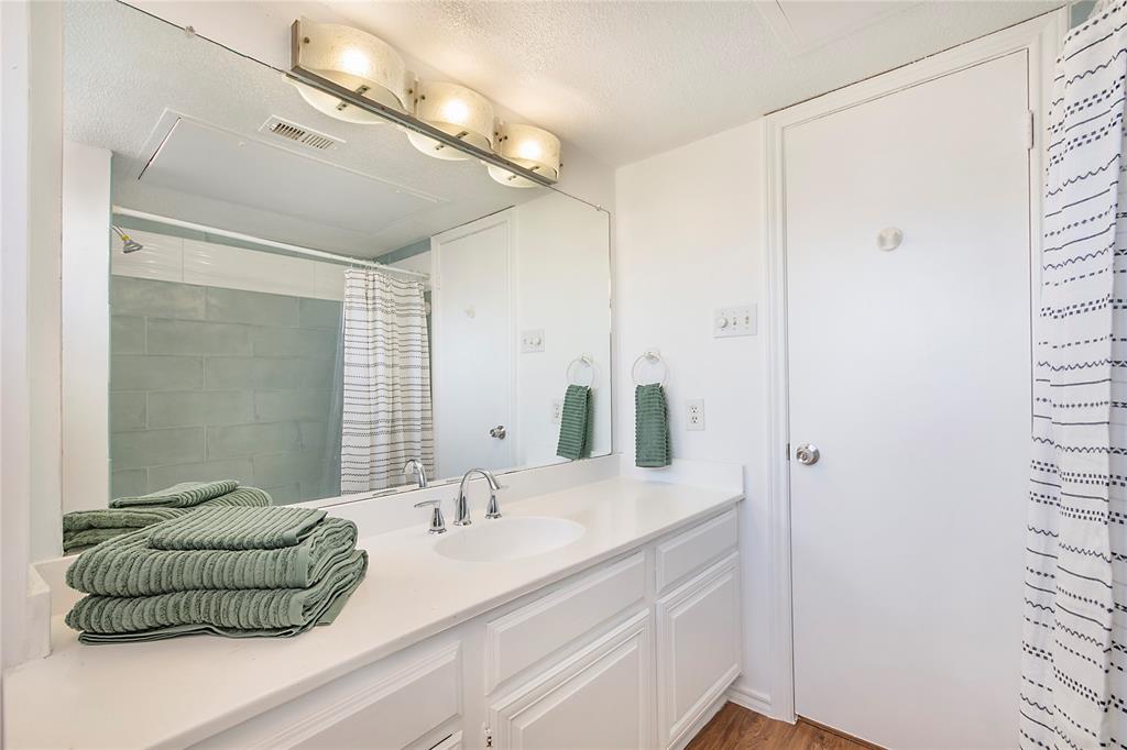 14277 Preston Road, Unit 823 Dallas, TX 75254 - Photo 27 of 31 Bathroom vanity featuring a white countertop, undermount sink, and chrome faucet