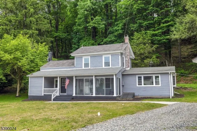 a view of a yard in front of a house with large windows