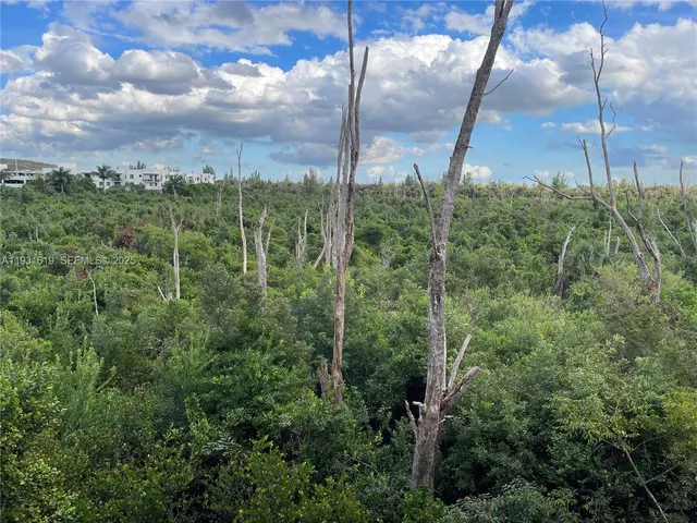 a kitchen with stainless steel appliances a stove a sink a oven a counter top space and living room view