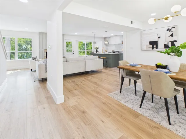 a living room with stainless steel appliances kitchen island granite countertop furniture and a wooden floor
