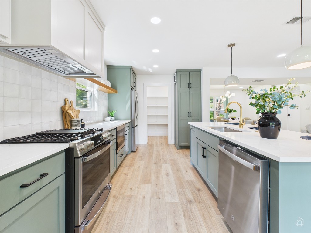 7019 Creighton Lane Austin, TX 78723 - Photo 18 of 40 a large kitchen with stainless steel appliances granite countertop a stove a sink and a refrigerator