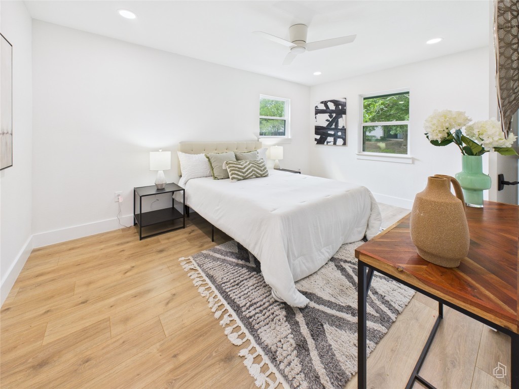 7019 Creighton Lane Austin, TX 78723 - Photo 21 of 40 a spacious bedroom with a bed and dresser with wooden floor