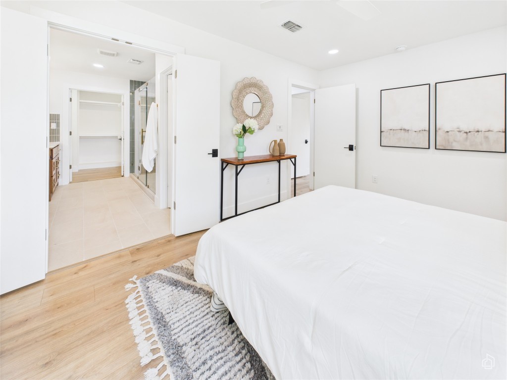 7019 Creighton Lane Austin, TX 78723 - Photo 22 of 40 a spacious bedroom with a bed and a chandelier