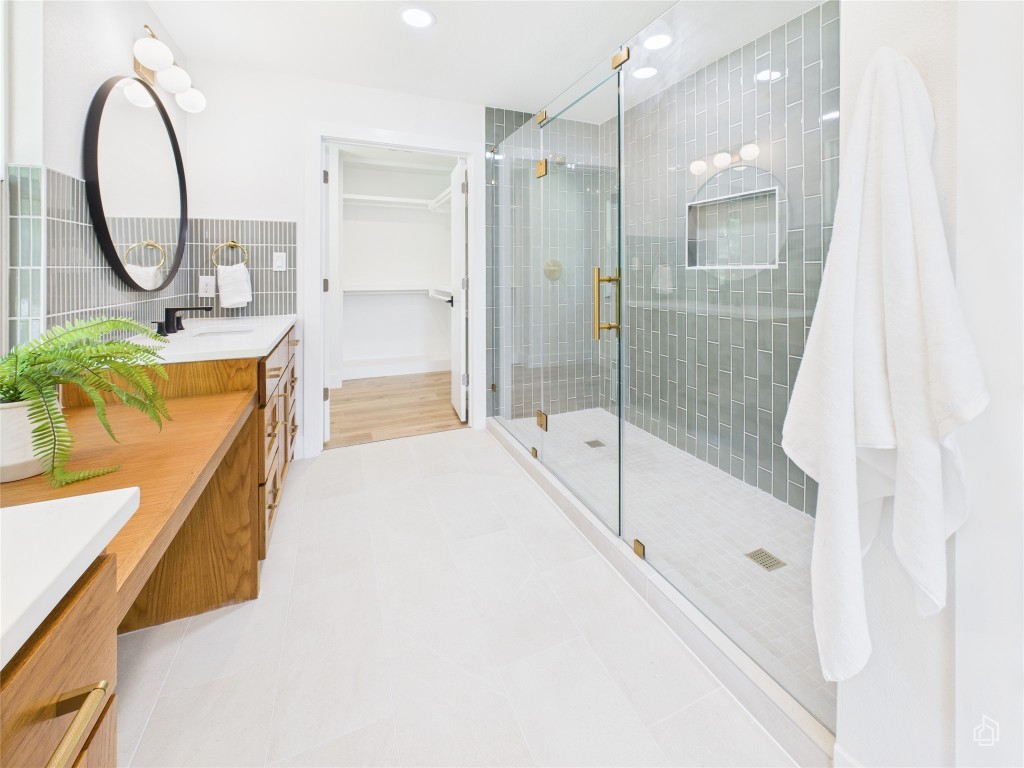 7019 Creighton Lane Austin, TX 78723 - Photo 24 of 40 a bathroom with a tub sink mirror and a shower