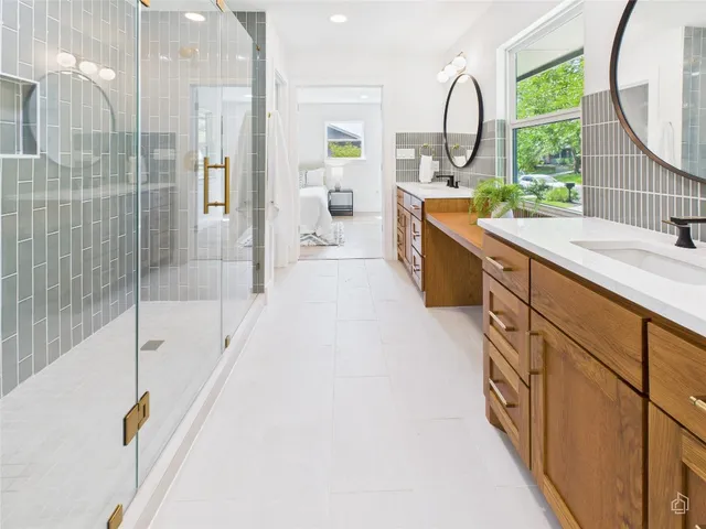 a large bathroom with a tub a double vanity sink a mirror and a shower