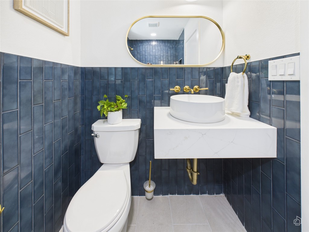 7019 Creighton Lane Austin, TX 78723 - Photo 33 of 40 a bathroom with a toilet sink and mirror