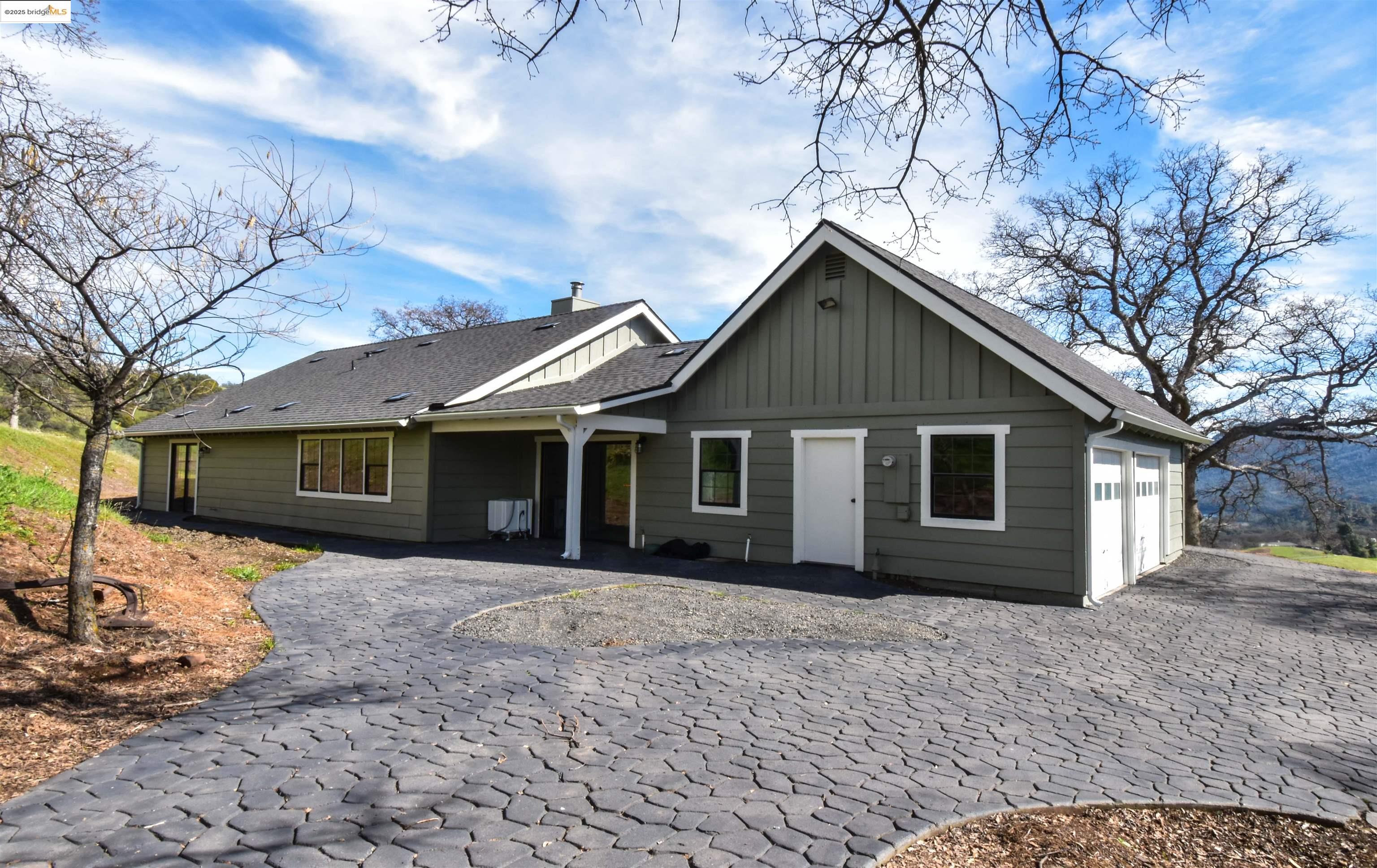 a front view of house with yard and trees around