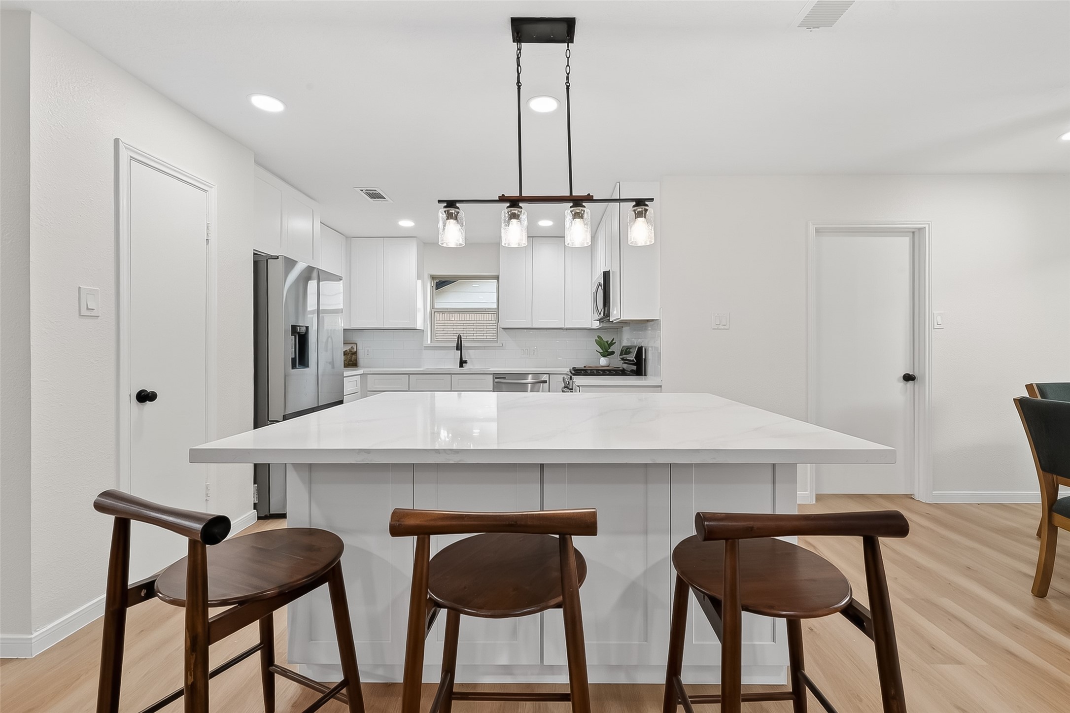 2914 Riata Lane Houston, TX 77043 - Photo 13 of 46 a kitchen with stainless steel appliances kitchen island a chandelier and refrigerator