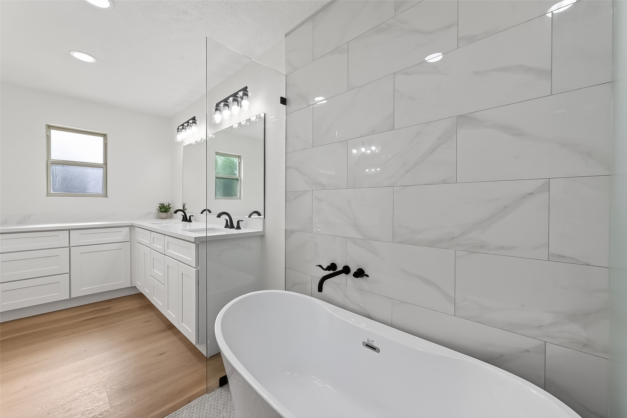 2914 Riata Lane Houston, TX 77043 - Photo 29 of 46 a bathroom with a bathtub a sink a window and a shower